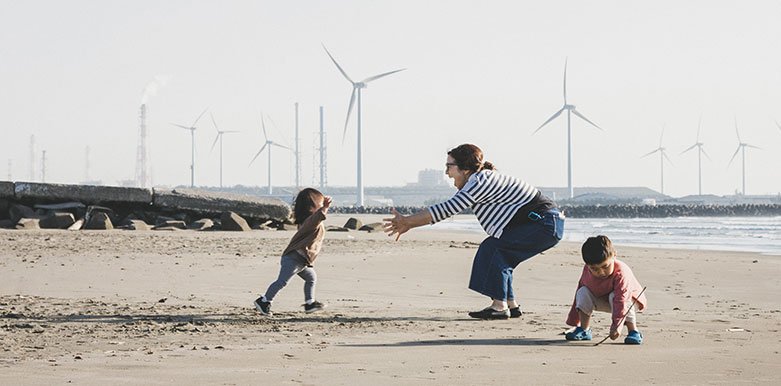 Mom playing with kids by the ocean